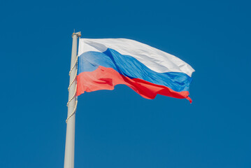 Fototapeta na wymiar Russian state flag waving in the wind against the blue sky