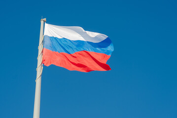 Fototapeta na wymiar Russian state flag waving in the wind against the blue sky
