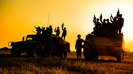 Silhouettes of army soldiers in the fog against a sunset, marines team in action, surrounded fire and smoke, shooting with assault rifle and machine gun, attacking enemy 