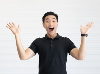 A young and cute handsome Asian man in a black shirt poses with power and full of energy. He shows hands to look like advertising and show something.