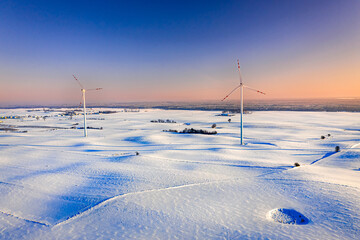 Stunning wind turbine on snowy field in winter
