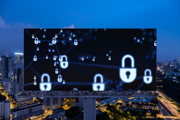 Padlock icon hologram on road billboard over panorama city view of Kuala Lumpur at night to protect business, Malaysia, Asia. The concept of information security shields.