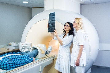 Radiologist with a male patient examining a mri scan