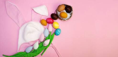 Easter background with painted eggs and colorful tulips and Easter bunny hat with ears. flat lay card.
