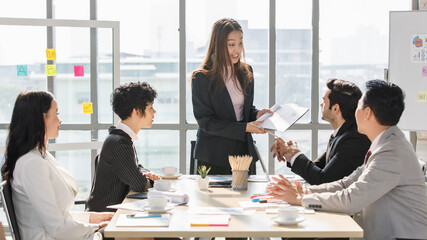 A Group of diverse businesspeople, Asan and Caucasian, make a conference together at the desk. Idea for good team at workplace