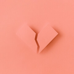 Geometric pink paper broken heart casting shadow on a paper background. Creative minimal love concept. Monochromatic flat lay arrangement.