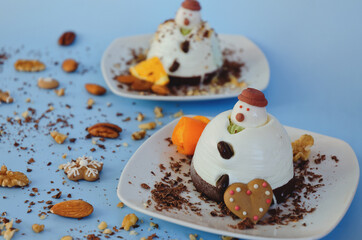 Ice cream background in the shape of two edible snowmen on white plates close up. Top view. Creative idea for Christmas and New Year festive desserts. Funny food idea for kids.
