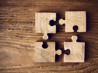 4 four wooden puzzle pieces. concept of connection people and brainstorming. isolated on wood...