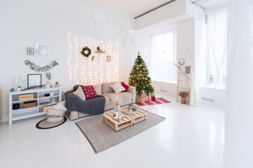 large very bright spacious stylish open plan Bali style apartment with hanging bed and panoramic windows. white floor and walls, simple wooden furniture. decorated with a christmas tree