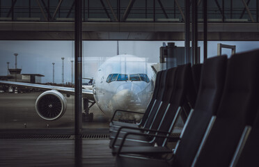 Parked aircraft on an airport through the gate window.