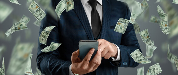 Online sports betting. A man in a suit is holding a smartphone and dollars are falling from the sky. Creative background, gambling.