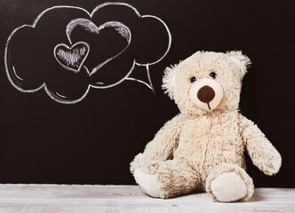 Teddy bear near blackboard. Valentines Day background. chalk heart.