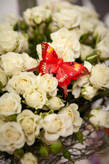 Bouquet of white roses with decorative butterfly. Flowers for the holiday. Decorations and ideas for parties and celebrations.