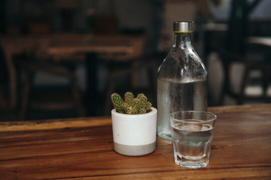 Drinking water. Glass of water with a bottle on table.