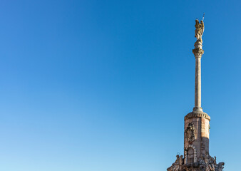 General shot of a column located in the city of Cordoba, leaving it to one side and taking more area of the image the beautiful and clear blue sky to isolate it and thus take even more prominence.