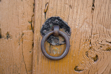 Front view of old doorknocker and orange painted wooden door