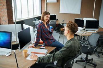 Male and female IT specialists talks in office