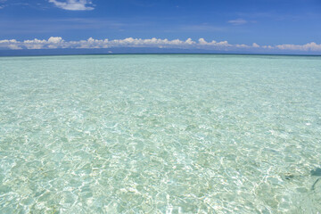 Crystal clear water on a blue sky with clouds background