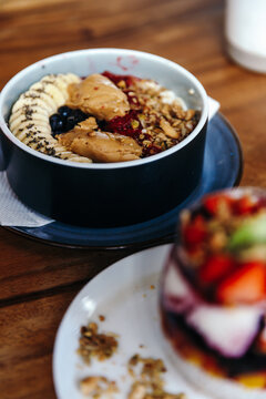 Healthy vegan breakfast with oatmeal bowl with banana, peanut butter, blackberries, raspberries, nuts, seeds and goji berries.