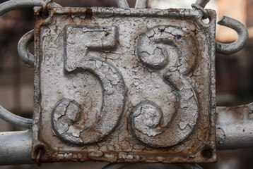 Old retro weathered cast iron plate with number 53 closeup