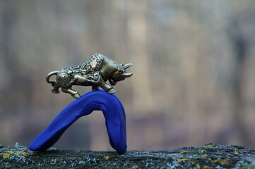 The figure of a metal bull rises up overcoming the obstacle.