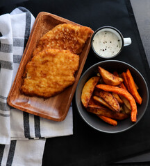 Chicken schnitzel with garlic mayo and sweet potato chips and spicy wedges 