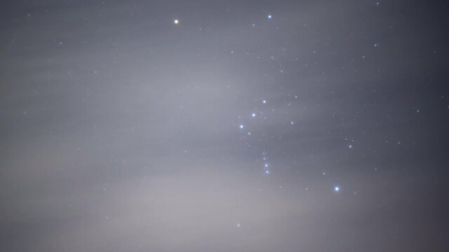 Orion Moving Across a Cloudy Sky at Night in Winter (Time Lapse)