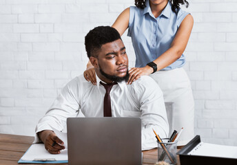 Lady boss sexually molesting her attractive male subordinate, putting hands on his shoulders at company office