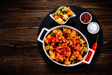 Pasta with tomato sauce, meat and parmesan on wooden table
