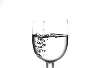 Water drops in glass goblet on white background