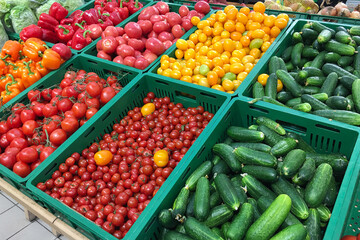 Cucumbers, tomatoes and bell peppers are sold at the grocery store. Vegetables on the market. 