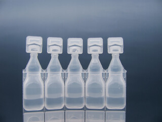 Set Lubricant eye drops in plastic pipettes blue background