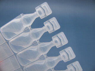 Set Lubricant eye drops in plastic pipettes blue background