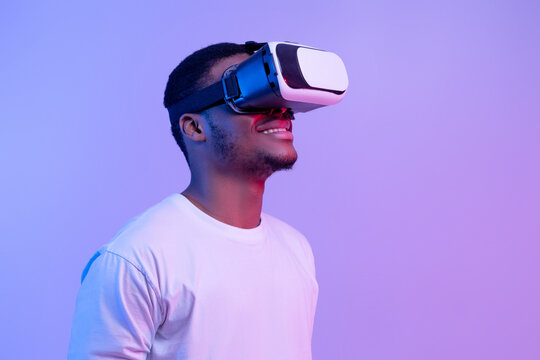 Modern technologies for entertainment. Excited black man wearing vr glasses looking aside