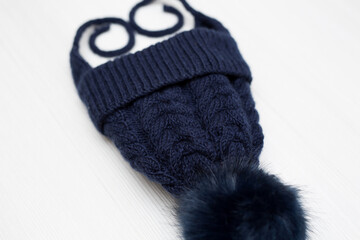 Children's knitted wool hat with a pompom, on a white background