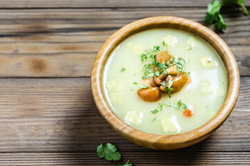 Cream mushroom soup croutons  in a bowl on wooden background. Space for text. - Powered by Adobe