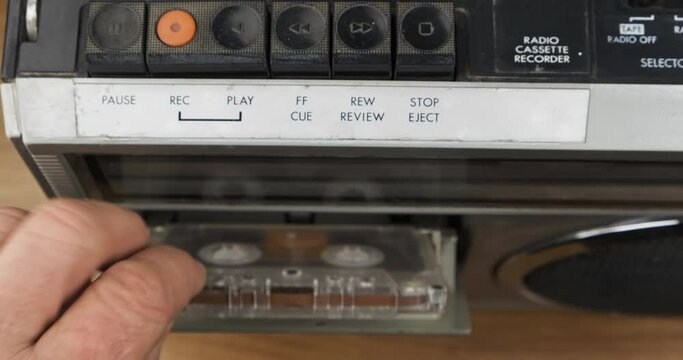 Press the eject button, turn the audio cassette over and press the play button. Old cassette recorder.