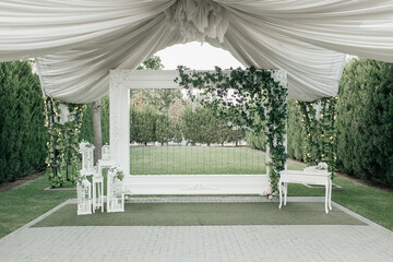 wedding white wall. green garden decor with draping lights and fresh plants. High quality photo