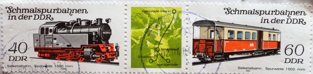 GERMANY, DDR - CIRCA 1984 : a postage stamp from Germany, GDR showing two narrow-gauge railroads in the GDR: historical locomotive 99 6001 and passenger car with a baggage compartment