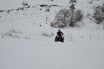 a man drive  an ATV in the snow 