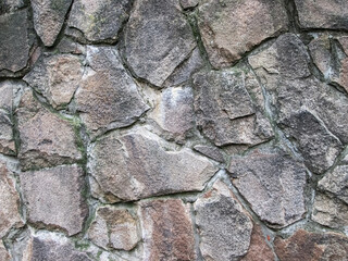 Hard stone cover. Large cobblestones embedded in the wall with cement.