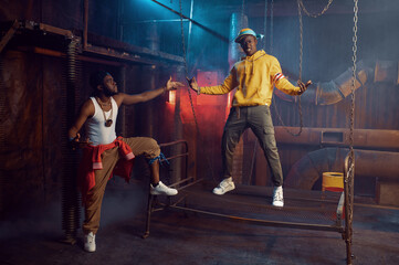 Two rappers posing, performing in cool studio
