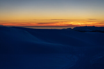 Fototapeta na wymiar tramonto con neve e mare