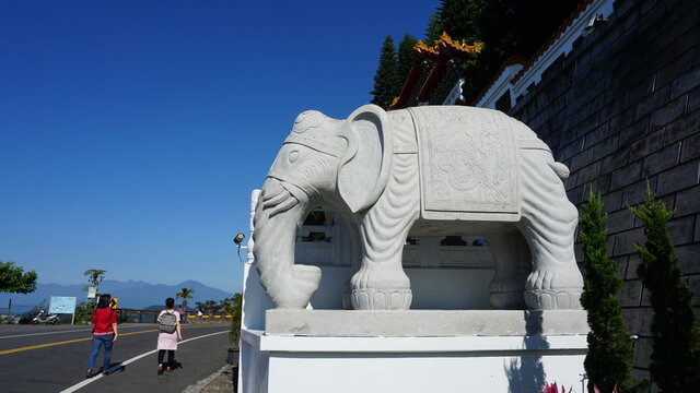 two hikers and an elephant statue at the Xuan Zang Temple, Sun Moon Lake, Yuchi Township, Nantou County, Taiwan, January