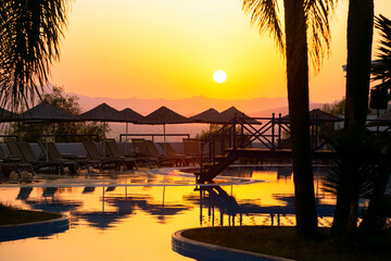 Beautiful sunset at a beach resort in the Aegean sea. Summer holiday concept.