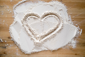 Valentine's Day. Heart symbol of love, drawn on flour, on a wooden texture. Copy space. Conceptual. 