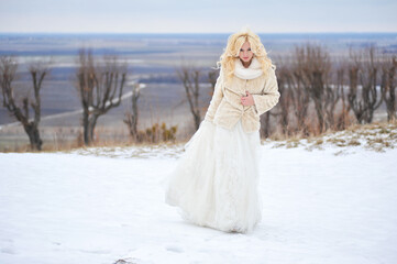 Beautiful bride near old castle on winter wedding day