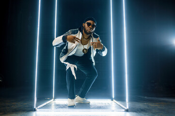 Stylish rapper in gold jewelry and sunglasses