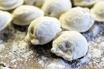 Traditional pelmeni or dumpling at cutting board. Homemade preparation food.