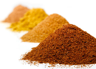 Heaps of various spices on white.